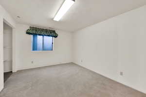 Unfurnished room with light colored carpet and baseboards