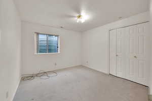 Unfurnished bedroom with carpet flooring, baseboards, and a closet