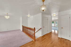 Staircase featuring a chandelier, wood finished floors, and baseboards