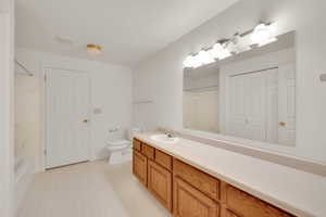 Bathroom featuring toilet, vanity, and shower / washtub combination