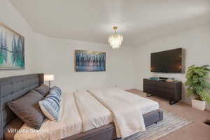 Bedroom featuring a chandelier and light carpet