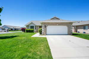 Ranch-style home with brick siding, a front lawn, a garage, driveway, and a shingled roof