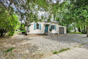 View of front facade with asphalt driveway and a garage