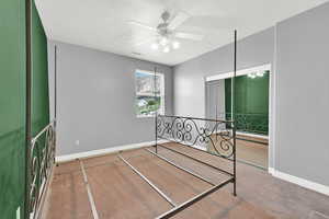 Carpeted bedroom featuring visible vents, baseboards, and ceiling fan