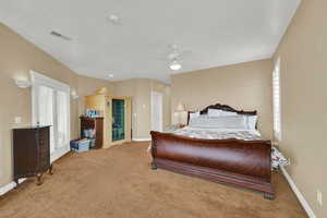 Carpeted bedroom featuring baseboards, ceiling fan, and visible vents
