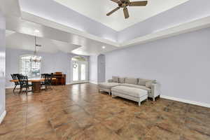 Living room with baseboards, ceiling fan with notable chandelier, arched walkways, and recessed lighting