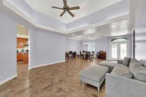 Living room featuring french doors, recessed lighting, baseboards, ceiling fan with notable chandelier, and arched walkways