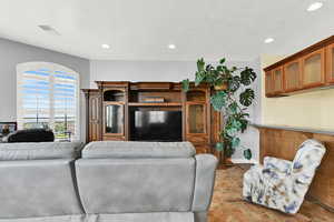 Tiled living area with visible vents, baseboards, and recessed lighting