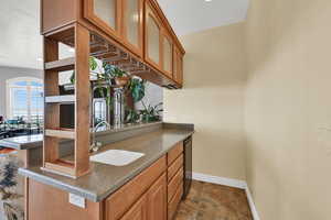 Bar with baseboards and a sink