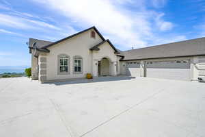 View of front of home with concrete driveway, stucco siding, roof with shingles, and a garage