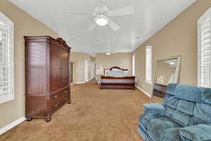 Bedroom with ceiling fan, light carpet, and baseboards