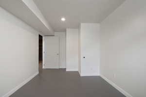 Spare room with concrete floors, baseboards, and recessed lighting