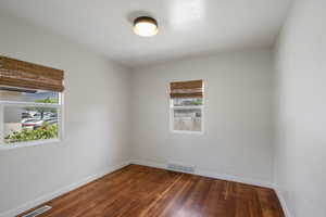 Empty room with wood-type flooring and baseboards