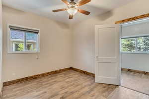 Bedroom with LVP floors, wood baseboards, and a ceiling fan