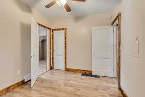 Bedroom with LVP floors, wood baseboards, and a ceiling fan and a closet