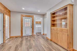 Dining room with LVP flooring, built in cabinets, backyard access, and recessed lighting