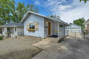 Cottage style home featuring a 2 car garage, gate, xeriscape yard, and a aluminum roof