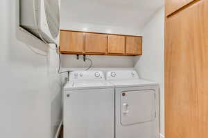 Dedicated laundry room with built in cabinet space and washer and dryer