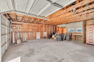 View of 2 car garage with tons of space and additional storage above