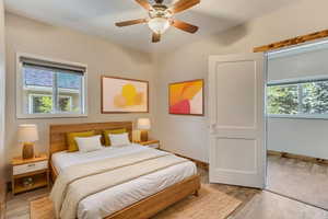 Bedroom with LVP floors, wood baseboards, and a ceiling fan
