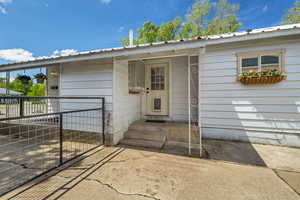 Backyard entrance to property with gate and aluminum roof