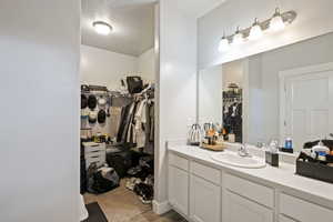 Bathroom with a walk in closet and vanity