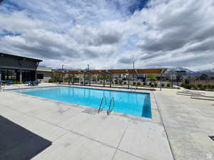 Community pool featuring a patio area and fence
