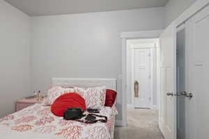 Bedroom with carpet flooring, baseboards, and a closet