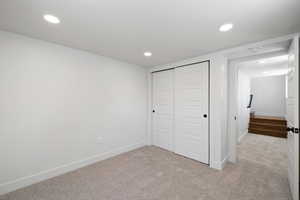 Unfurnished bedroom with carpet floors, recessed lighting, baseboards, and a closet
