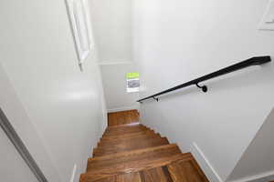 Stairway featuring wood finished floors and baseboards