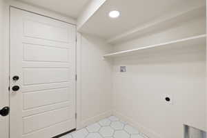 Washroom with hookup for a washing machine, hookup for an electric dryer, baseboards, recessed lighting, and light tile patterned floors