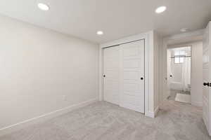 Unfurnished bedroom featuring carpet flooring, a closet, recessed lighting, and baseboards