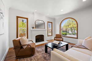 Living room with recessed lighting, baseboards, a fireplace, and wood finished floors