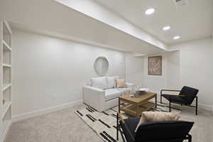 Living room featuring light colored carpet, baseboards, and recessed lighting