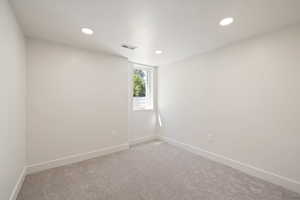 Empty room featuring baseboards, recessed lighting, and carpet flooring