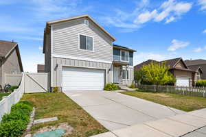 Traditional-style house featuring board and batten siding, a garage, concrete driveway, and a gate