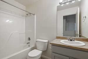 Bathroom featuring toilet, vanity, and  shower combination
