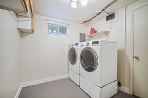 Washroom with washing machine and clothes dryer, cabinet space, and baseboards