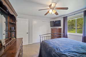 Bedroom featuring light colored carpet, a closet, and a ceiling fan
