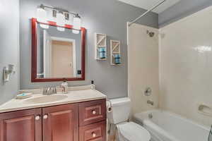 Bathroom with shower / bath combination, vanity, and toilet