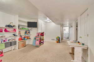 Playroom featuring carpet flooring, a textured ceiling, and baseboards