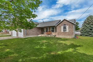 Single story home featuring brick siding, concrete driveway, a front lawn, and a garage