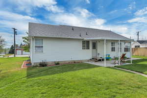 Back of property with a patio area, entry steps, and roof with shingles