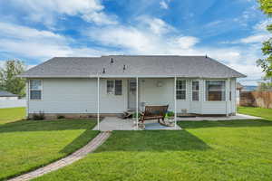 Rear view of property with a patio area and roof with shingles