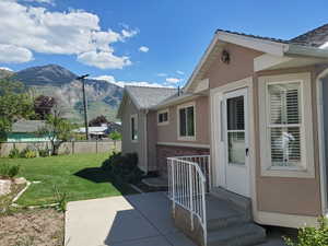 View of home's exterior with brick siding, a mountain view, stucco siding, and a patio area