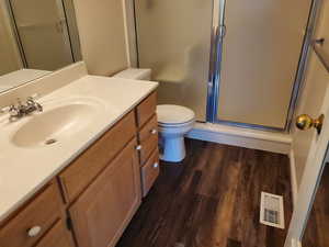 Full bath with vanity, a stall shower, and dark wood-style flooring