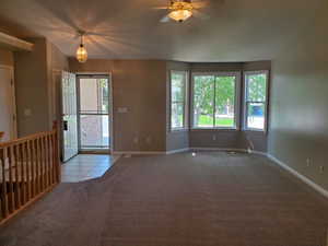 Carpeted foyer entrance with healthy amount of natural light, tile patterned flooring, and ceiling fan