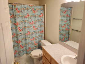 Full bath with toilet, vanity, and tile patterned floors