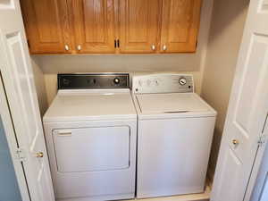 Clothes washing area with washing machine and dryer and cabinet space