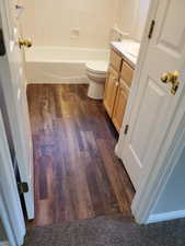 Full bathroom featuring vanity, dark wood-type flooring, and shower / bathtub combination